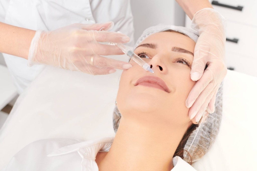 At a renowned aesthetics med spa in Reno, a professional expertly administers a cosmetic injection to the upper lip area while the client relaxes on the treatment table.