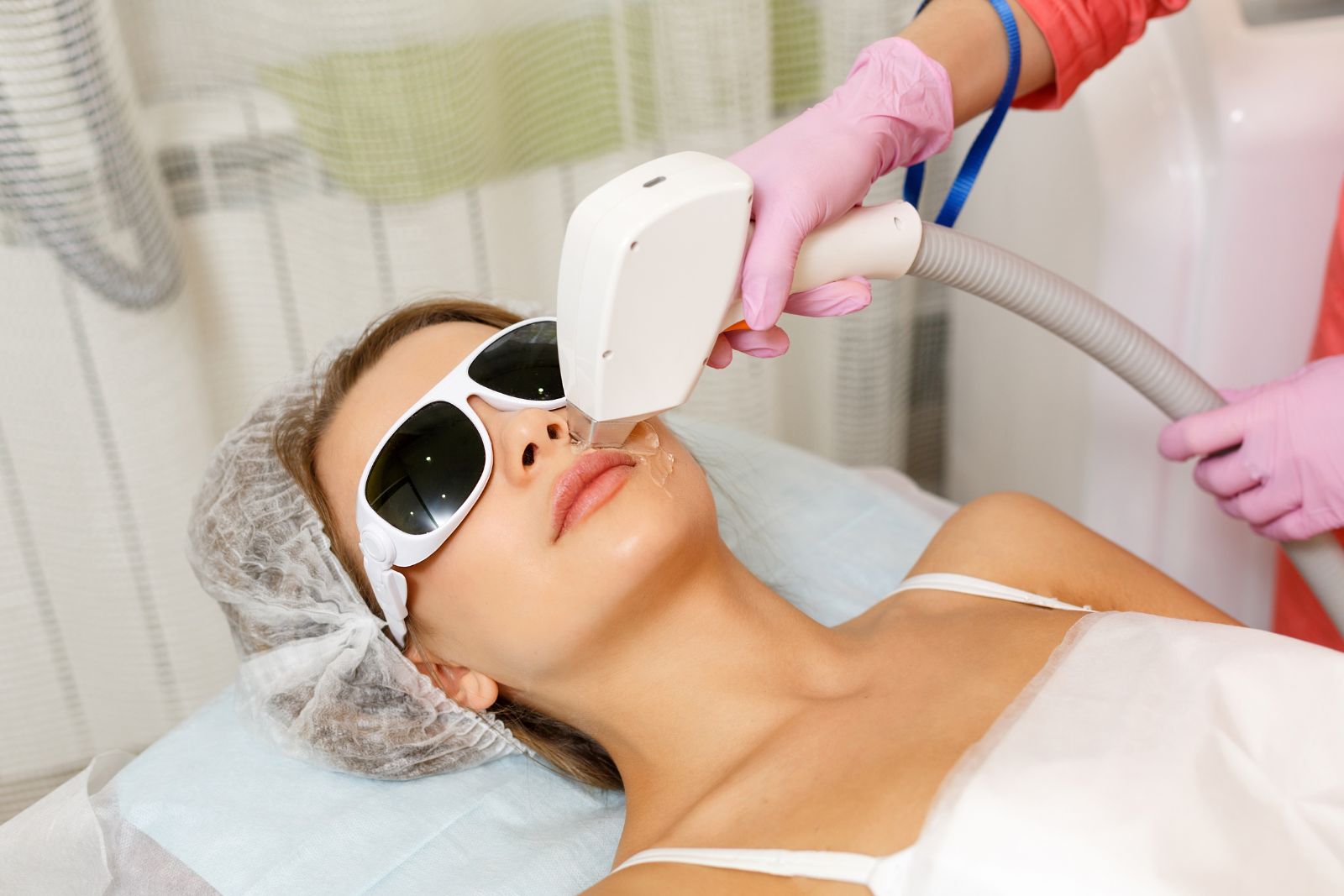A woman is getting a laser treatment at a beauty salon.