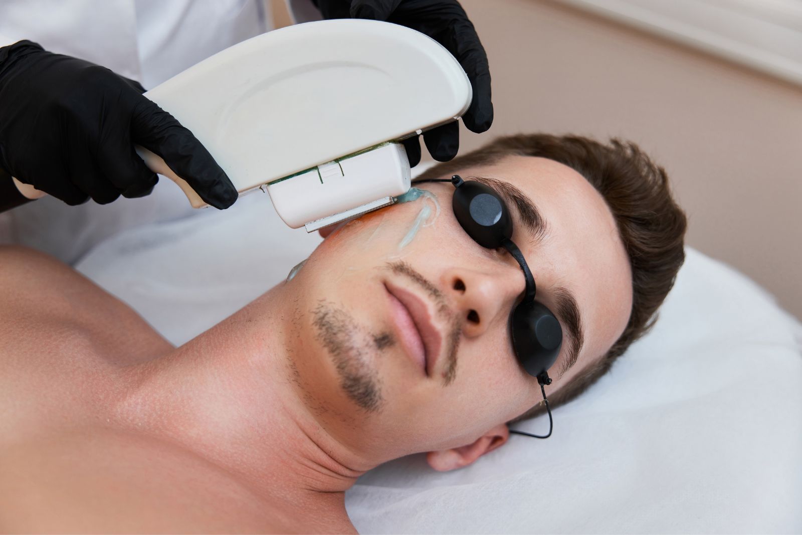 A man is getting a laser treatment on his face.