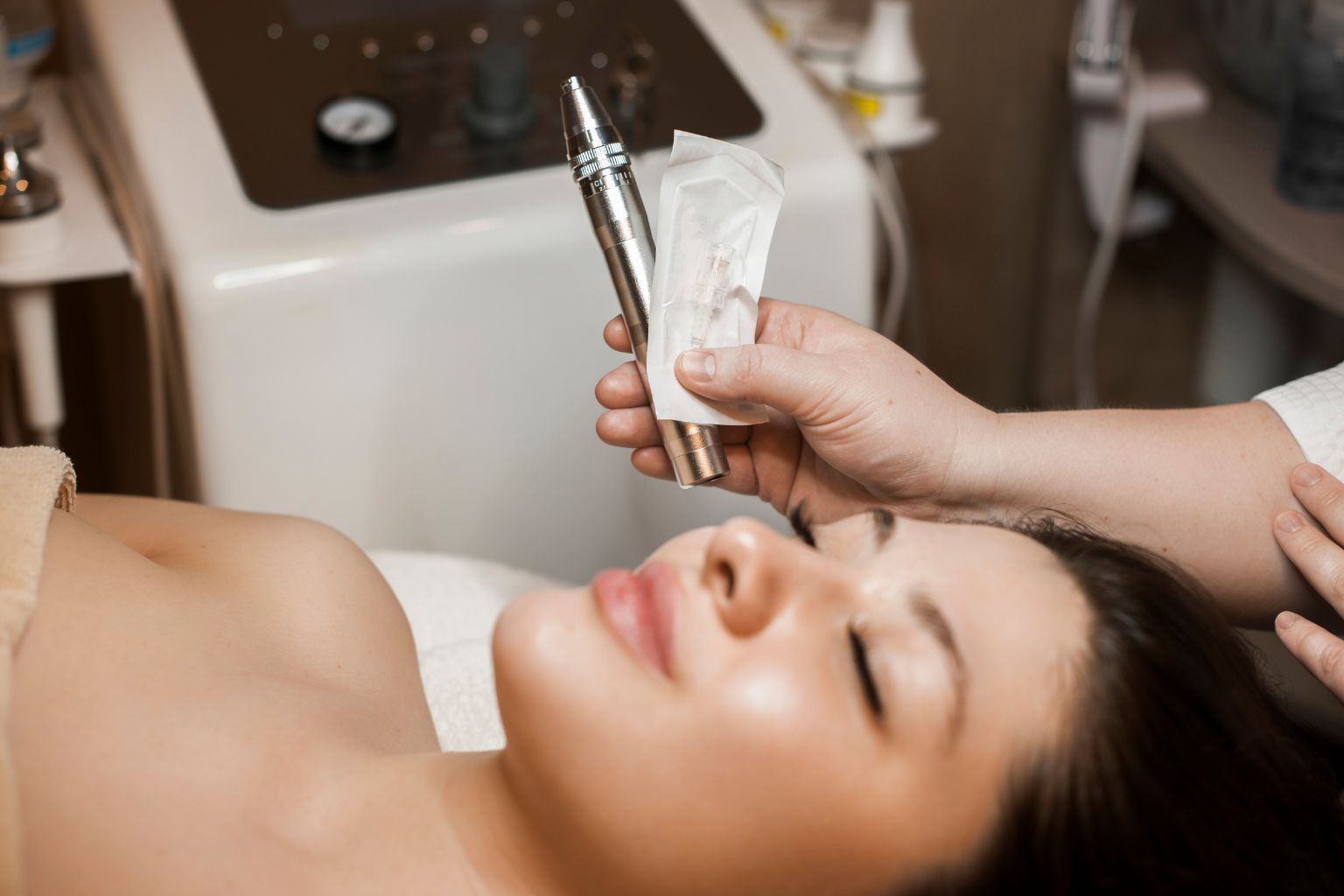 Person receiving a facial treatment with a microdermabrasion tool while lying down.