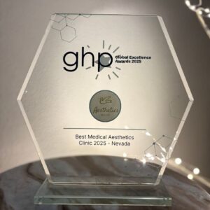 A hexagonal glass award sits on a marble surface, engraved with “ghp Global Excellence Awards 2025,” honoring “Best Med Spa & Medical Aesthetics Clinic 2025 – Reno, Nevada.”.