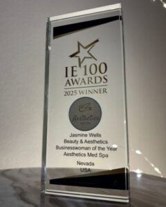 IE 100 Awards 2025 Winner trophy presented to Jasmine Wells for Beauty and Aesthetics Businesswoman of the Year at Aesthetics Med Spa in Nevada.